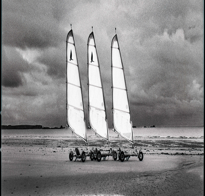 Mostra Fotografica di David Zhronski: la foto di tre barche a vela su una spiaggia